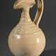 Bauchige Weinkanne mit geriffeltem Hals, appliziertem Blatt auf der Wandung sowie verzogenem Ausguss und Drachenkopfhenkel, heller Scherben mit blass-strohfarbener Glasur und Craqulé, unten unglasiert, Tang-Zeit, 7./8.Jh… - фото 1