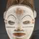 Punu-Lumbo Maske, Gabun, Kaolin weiß gefasstes Frauengesicht, einen positiv wirkenden Wiedergänger darstellend, fein geschnitzte Züge und Schmucknarben an den Schläfen, turmförmiger Haaraufbau, Abrieb an Kinn und Stirn, … - Foto 1