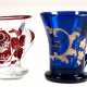 2 Biedermeier-Henkelbecher, mit Abriß, 1x farbloses Glas, rubinrot mit Spruch "Gesundheit", H. 9,5 cm, 1x blaues Glas, floraler Dekor mit Spruch "Zum Andenken", H. 10 cm, jeweils mit Gebrauchspuren - photo 1