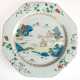 Großer China-Teller, achteckig, Periode Chien-Lung (1736-1795), leicht blaugraue Glasur bemalt mit polychromen Emailfarben famille rose, im Spiegel Darstellung einer chinesischen Landschaft, Fahne mit Blumenranken, dazwi… - Foto 1