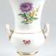 Meissen-Amphorenvase, auf rundem Fuß, mit 2 seitlichen Henkeln, auf Schauseite Bunte Blume 2 und Streublümchen, Goldränder, Schwertermarke mit 2 Schleifstrichen, H. 26 cm - Foto 1
