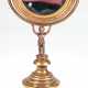 Schminkspiegel, figürlich, Bronze, Frankreich 19. Jh., auf beschwertem, getrepptem Rundfuß steht plastischer Putto und trägt schwenkbaren Spiegel (mit Blindstellen), Ges.-H. 30 cm, Spiegel-Dm. 11 cm - Foto 1