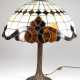 Tischlampe im Tiffany-Stil, 1-flammig, Bronzefuß in Form eines Baumstammes, runder Schirm aus beige/braunem Kunstglas, H. 60 cm, Dm. 56 cm - photo 1