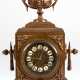 Historismus-Pendule, um 1880, Bronzeguß, 1/2-Stundenschlag auf Glocke (nicht fkt.), reich reliefiertes Gehäuse mit Amphore als Bekrönung, Pendel mit Blattfederaufhängung, reliefiertes Zifferblatt mit Emailleplaketten mit… - Foto 1