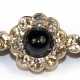 Saphir-Diamant-Stabbrosche, 585er GG/WG (geprüft), Goldschmiedeanfertigung, ausgefasst mit 1 kegelförmigen Saphir-Cabochon von ca. 1,50 ct. und 20 getönten Achtkant-Diamanten von zus. ca. 0,30 ct., Si-P1, Broschierung mi… - Foto 1