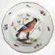Meissen-Teller, 1850-1924, im Spiegel polychrome Vogelmalerei(z.T. berieben), Fahne mit Floral- und Insektenmalerei, goldener Zierrand etwas berieben und mit kl. Haarriß, Standring mehrfach best., Knaufschwertermarke mit… - Foto 1 Meissen-Teller, 1850-1924, im Spiegel polychrome Vogelmalerei(z.T. berieben), Fahne mit Floral- und Insektenmalerei, goldener Zierrand etwas berieben und mit kl. Haarriß, Standring mehrfach best., Knaufschwertermarke mit… - Foto 1
