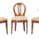 Drei Stühle im klassizistischen Stil um 1820, Nussbaum, spitz zulaufende und gekehlte Vierkantbeine, Zarge mit geschnitztem Flechtbanddekor und Rosettenmotiv, die Rückenlehne als ovaler Rahmen mit Vertikalverstrebung und geschnitzter Schleifenbekrönung, H - photo 1