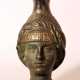 Bronze jug after the ancient, in shape of a female head with long neck as stand and bowed pressed spout - photo 1