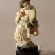 Japanese ivory netsuke showing a woman holding a baker and a bag in traditional dress, partly engraved - photo 1
