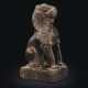 A SMALL BLACKISH STONE FIGURE OF A SEATED LION - Foto 1