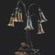 Tiffany Studios. A SEVEN-LIGHT 'LILY' FAVRILE GLASS AND PATINATED BRONZE TABL... - Foto 1