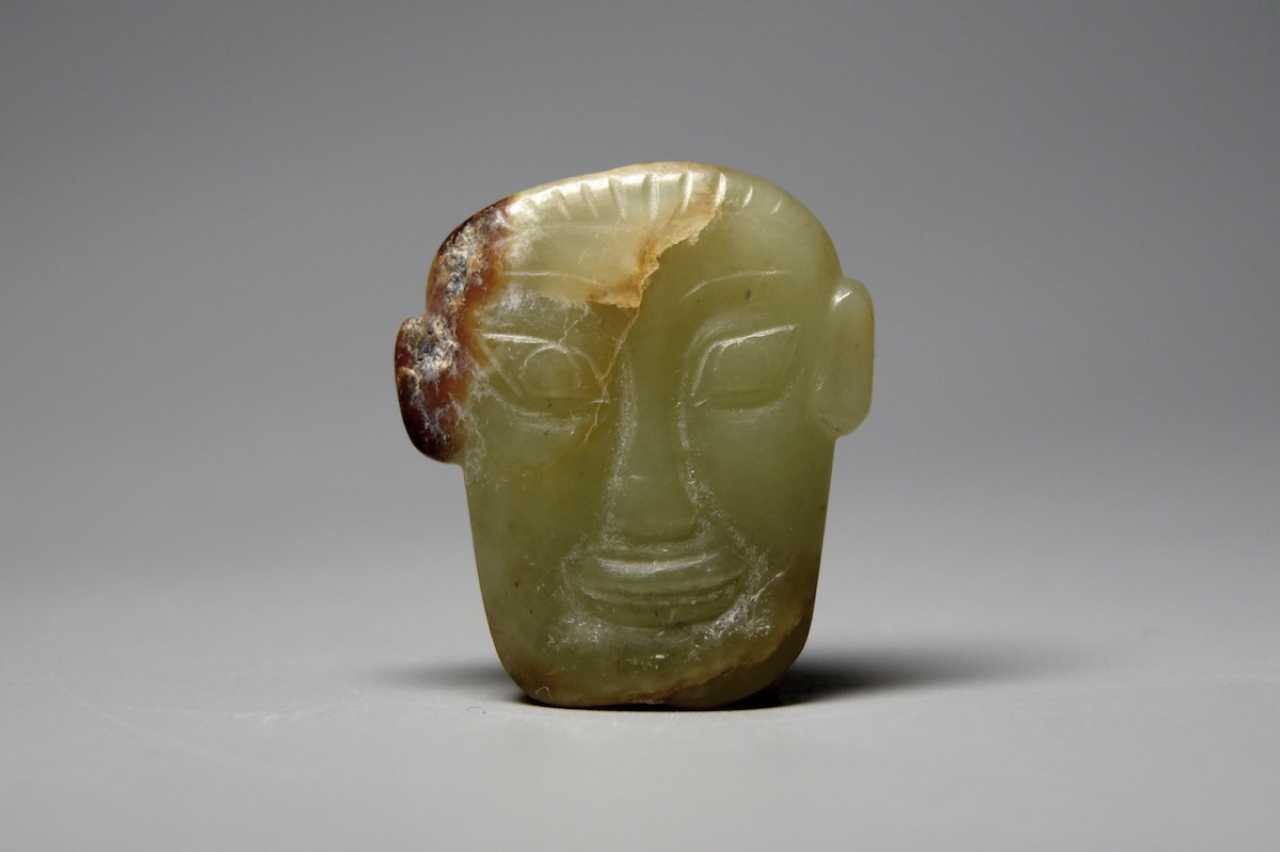 A JADE HUMAN FACE ORNAMENT SHANG DYNASTY (16001046BC). Auction catalog