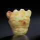 A RARE PALE YELLOWISH-GREEN JADE HORNED MASK PENDANT - photo 1