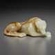 A PALE GREY AND MOTTLED RUSSET JADE FIGURE OF A RECUMBENT HOUND - фото 1