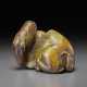 A BROWN AND OLIVE-GREEN JADE FIGURE OF A RECUMBENT CAMEL - Foto 1