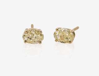 A Pair of stud earrings light fancy yellow diamonds A Pair of stud earrings light fancy yellow diamonds
