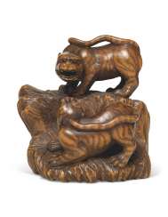A WOOD NETSUKE OF TWO TIGERS A WOOD NETSUKE OF TWO TIGERS