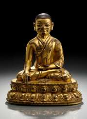 FIRE GILT BRONZE OF A SEATED LAMA FIRE GILT BRONZE OF A SEATED LAMA