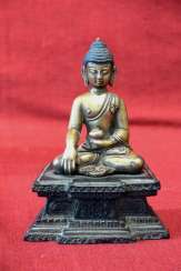 Gilded bronze statuette of Shakyamuni Buddha on a wooden base Gilded bronze statuette of Shakyamuni Buddha on a wooden base