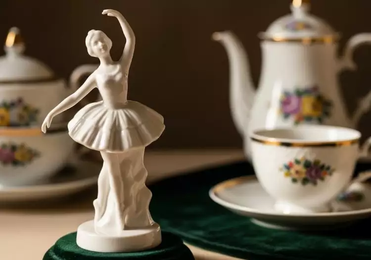 Человек внимательно рассматривает клеймо на дне фарфоровой чашки