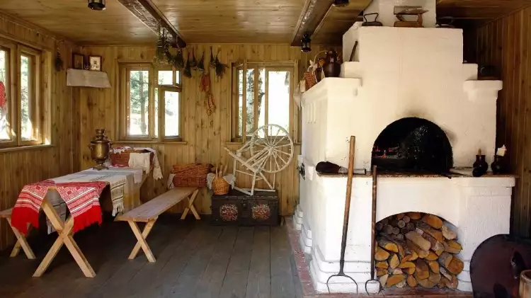 Русский стиль. Интерьер в классическом стиле «русской избы» с печкой и деревянной прялкой в русском стиле