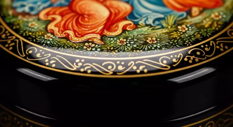 Фрагмент лаковой миниатюры на крышке шкатулки, демонстрирующий тончайшую роспись и глубокий блеск лакового покрытия.