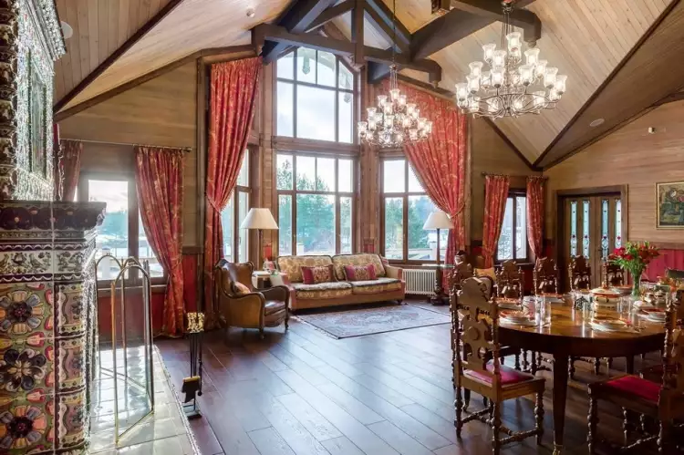 Русский стиль. Интерьер гостевого пространства с панорамными окнами и камином, отделанным изразцовой плиткой в русском стиле