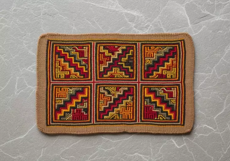 Фрагмент инкского текстиля с яркими геометрическими узорами токапу, свидетельствующий о высочайшем мастерстве ткачей и социальном значении ткани.